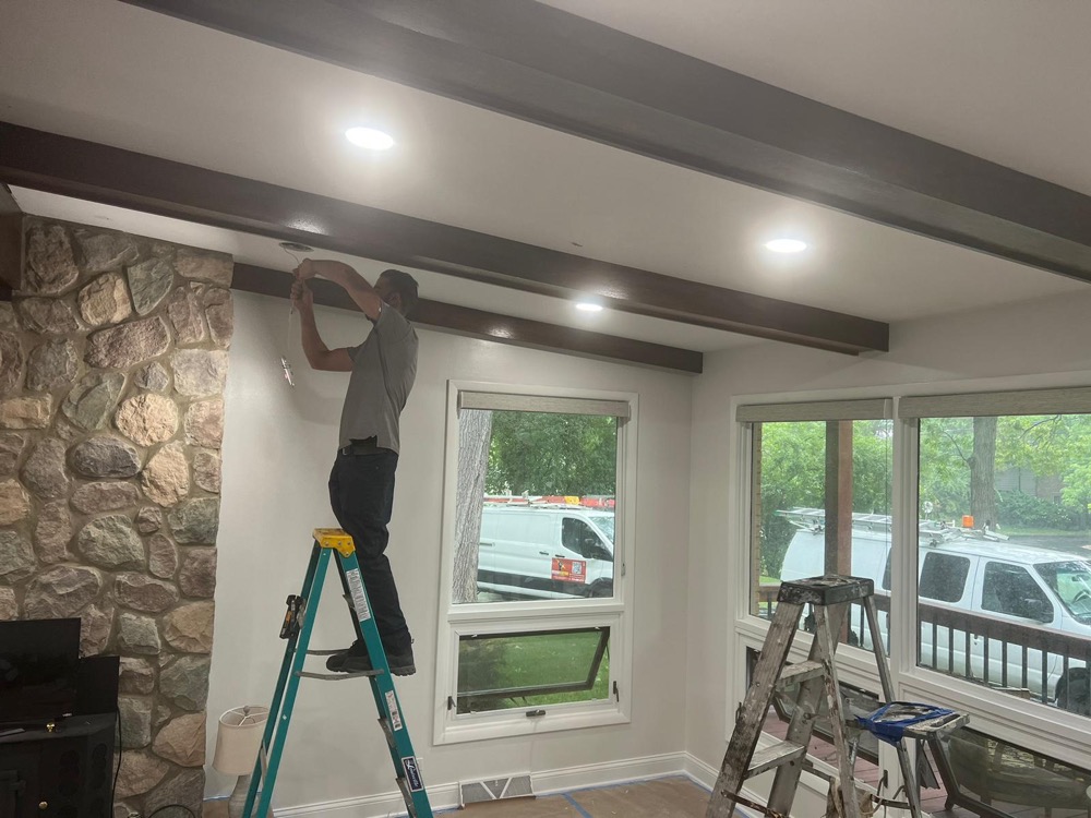 Rescue Electric technician installing recessed lighting in a remodeled living room